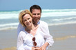 Couple hugging in front of the surf