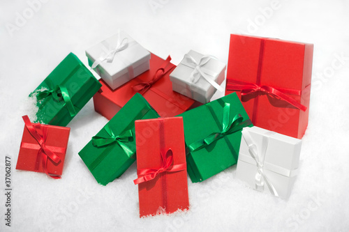 Photo: Gift boxes isolated on white background in snow. Gift boxes isolated on white background in snow.