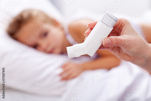 Photo: Sick kid with inhaler in foreground Sick kid with inhaler in foreground