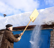 Photo: Man removing snow from a roof with a shovel Man removing snow from a roof with a shovel