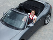 Satisfied motor mechanic sitting in a cabrio and shows thumb up