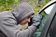 Dieb schaut durch Autoscheibe