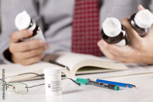 Photo: which one? stress man choosing medicines in his hand. which one? stress man choosing medicines in his hand.