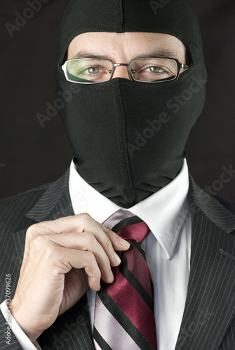 Photo: Businessman In Balaclava Straightens Tie Businessman In Balaclava Straightens Tie