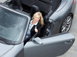 Satisfied female customer sitting in a cabrio and shows thumb up