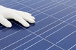 Hand mit weissem Handschuh vor Solarzellen Hand mit weissem Handschuh vor Solarzellen