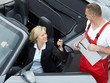 Foto: Customer sitting in a car and gets her key from master mechanic Customer sitting in a car and gets her key from master mechanic