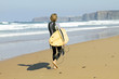 Surfer walking with his surfboard at the beach