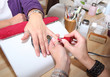 Roter Nagellack wird im Nagelstudio aufgetragen
