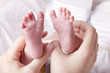 mother showing feet of newborn baby