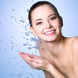 Smiling beautiful woman washing her face
