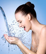 Happy woman washing face under water
