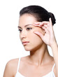Woman pinching skin near her eye Woman pinching skin near her eye