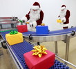 Two Santa Clauses working in Xmas Presents Factory