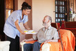 Photo: elderly senior being brought meal by carer or nurse elderly senior being brought meal by carer or nurse