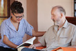 Photo: carer reading to senior carer reading to senior