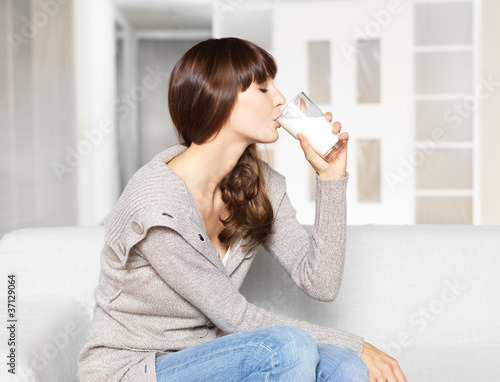 Foto: Young woman drinking glass of milk Young woman drinking glass of milk