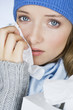 A woman crying, wiping her tears away with a tissue