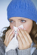 A young woman blowing her nose, close-up