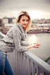 Young sexy girl posing in sun rays on bridge
