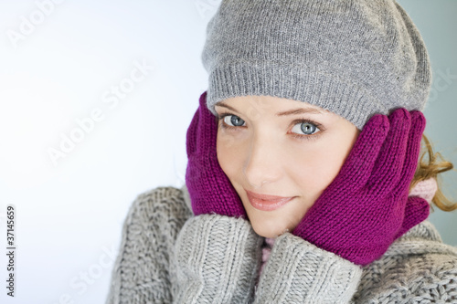 Photo: A young woman with her hands over her ears, trying to keep warm A young woman with her hands over her ears, trying to keep warm