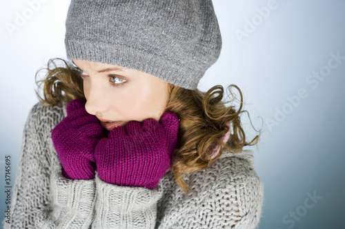Photo: A young woman wearing hat and gloves, trying to keep warm A young woman wearing hat and gloves, trying to keep warm