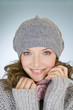 Portrait of a young woman wearing a grey woollen hat, smiling