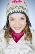 A young woman holding a handful of snow, smiling