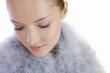 Foto: Portrait of a young woman wearing a feather shrug, looking down Portrait of a young woman wearing a feather shrug, looking down