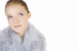 Portrait of a young woman wearing a feather shrug, looking up