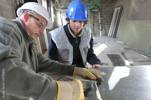 Foto: Zinc worker and apprentice in workshop Zinc worker and apprentice in workshop