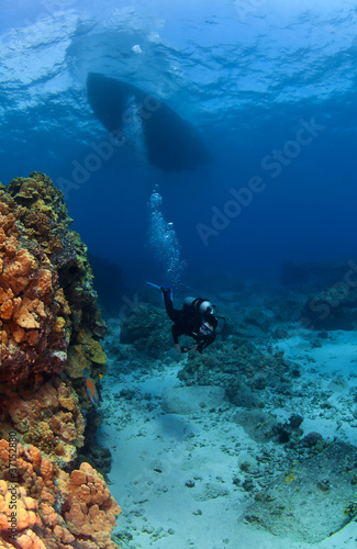 Photo: Scuba Diver exploring under the Boat Scuba Diver exploring under the Boat