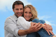 Couple sat hugging each other in park