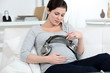 Pregnant woman putting headphones on her belly