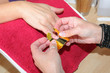 Nageldesignerin legt Schablone an Fingernagel einer Kundin