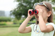little girl watching through binoculars
