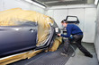 Worker painting a car. Worker painting a car.