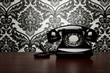 Photo: Vintage telephone over ornate wallpaper with copy space Vintage telephone over ornate wallpaper with copy space