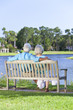 Rear View Senior Couple Sitting On Park Bench