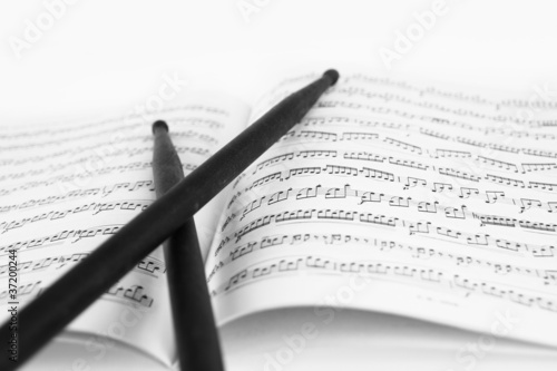 Foto: Drum sticks on the music sheet Drum sticks on the music sheet