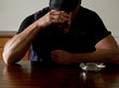 man drinking and smoking at a bar