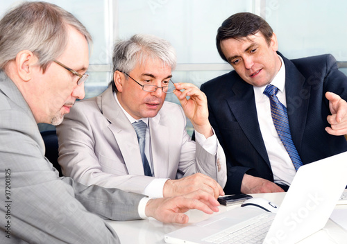Photo: Portrait of three businessmen at the computer. Portrait of three businessmen at the computer.
