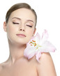 Photo: Beautiful young girl with flower on shoulder - isolated Beautiful young girl with flower on shoulder - isolated