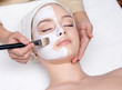 Woman having a facial cosmetic mask