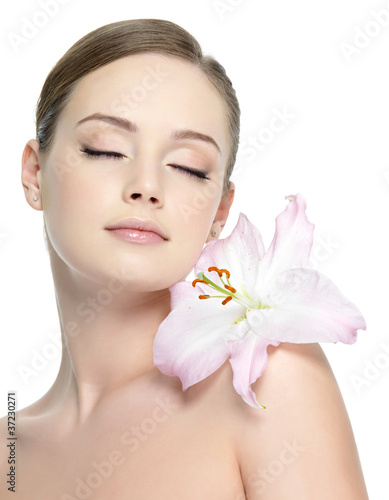Photo: Beautiful young girl with flower on shoulder - isolated Beautiful young girl with flower on shoulder - isolated