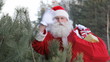 Santa waves at camera holding his sack
