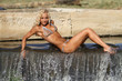 Blonde lady sitting on river's edge