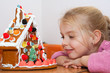 girl marvel at the selfmade gingerbread house