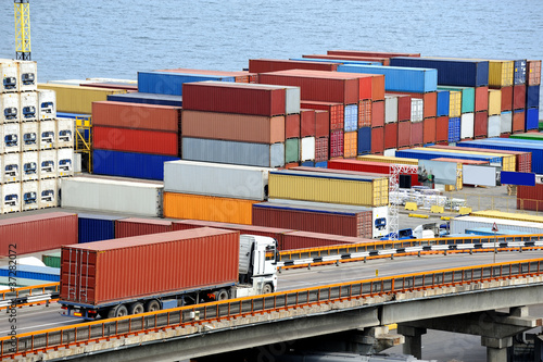 Photo: truck transports container to warehouse near the sea truck transports container to warehouse near the sea
