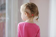 Adorable smiling little girl by the window